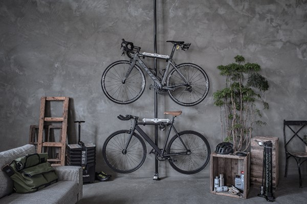 Two road bikes hanging on wall mounted storage